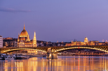 Obraz premium Evening in Budapest, Parliament against the background of the Margaret Bridge, the reflection of lights in the water