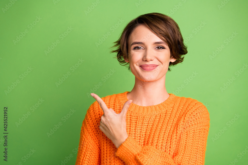 Sticker Photo of positive happy young woman point finger empty space feedback promoter isolated on green color background