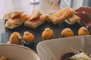 Racion de croquetas gourmet presentadas en una tabla de piedra en un buen restaurante