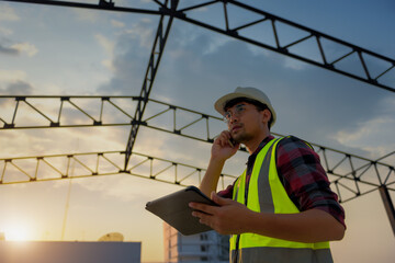 Engineering Consulting People on construction site holding tablet in his hand and call. Management in business workflow and Building inspector with Information and Communications Technology.