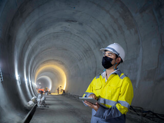 Young Asian tunnel engineering working at construction site.