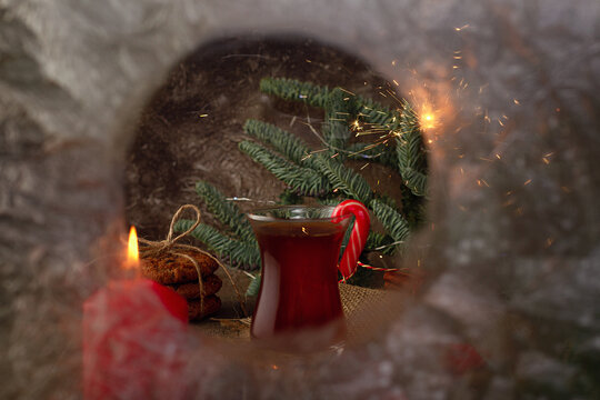 Hot tea on a winter evening. People are celebrating the holiday. Armuda with tea. Looking at the holiday through a frozen window. Selective focus.