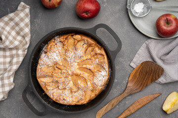 Sliced apple pie in iron pan on the table . Flat lay, close up, top view 