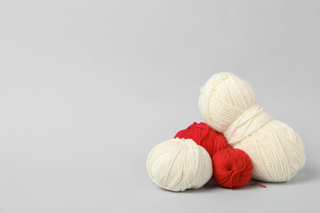 Fototapeta na wymiar Soft woolen yarns on white background, space for text