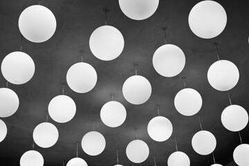 white spherical lamps hanging from concrete ceiling, B/W