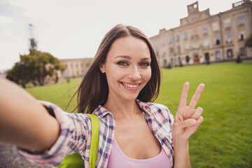 Photo of young attractive girl happy positive smile shoot selfie cell phone how peace cool v-sign...