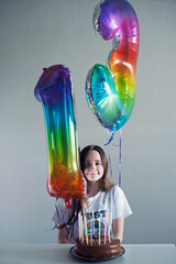 Cute teenager with happy birthday baloons
