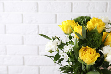 Beautiful bouquet with peony tulips near white brick wall, closeup. Space for text