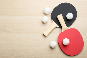 Ping pong rackets and balls on wooden table, flat lay. Space for text