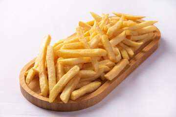 French fries placed on a long wooden plate, white background, selective focus.