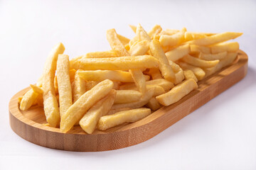 French fries placed on a long wooden plate, white background, selective focus.