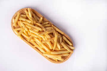 French fries placed on a long wooden plate, white background, Top view.