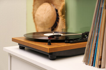 Turntable with vinyl record on white table indoors, space for text