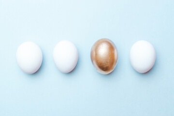 Easter pattern. Golden, white colour egg on pastel blue background in Happy Easter decoration. Spring holiday top view concept.