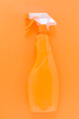 Orange chemical bottle on monochrome background. Clean up concept. Flat lay of domestic cleaning kit