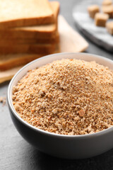 Fresh breadcrumbs in bowl on black table
