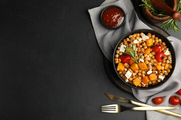 Delicious fresh chickpea salad served on black table, flat lay. Space for text