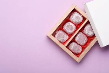 Box of delicious mochi on light background, top view with space for text. Traditional Japanese dessert