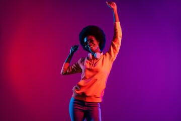 Photo of cheerful girlish clubber lady dance raise arm wear sweatshirt headphones eyewear isolated gradient dark background