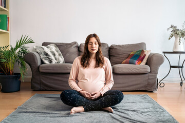 Obraz premium Beautiful Pregnant Woman Doing Yoga At Home.
