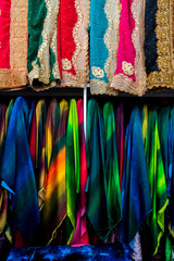Rolls of fabric and textiles for sale stacked on shelves in shop,View of cloth rolls of different colors and patterns on shelves in fabric store, Colorful traditional indian, turkey costumes