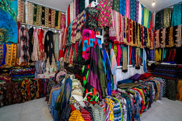 Fototapeta premium Rolls of fabric and textiles in a factory shop. Multi different colors and patterns on the market Fabrics in rolls. Fabric store 