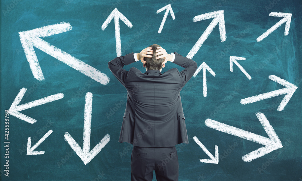 Poster choice concept with businessman grabs his head and looking at green chalkboard with arrows directed 