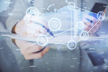 Double exposure of social network sketch hologram and woman holding and using a mobile device.