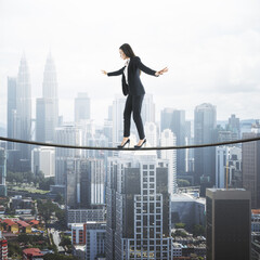 Risk challenge in business concept with businesswoman trying to walk the rope above city