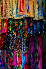 Clothes in shop, Rolls of fabric and textiles for sale stacked on shelves in shop, View of cloth rolls of different colors and patterns on shelves in fabric store.