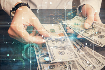 Double exposure of technology drawing hologram and us dollars bills and man hands. Data concept
