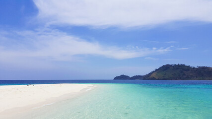 Beautiful white clouds on blue sky over calm sea with sunlight reflection.Sunny sky and calm blue ocean. Vibrant sea with clouds on horizon.