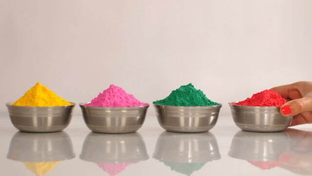 Multicolor Gulal (Holi colors) in metallic bowls to celebrate the Holi festival. The traditional Indian festival of colors - Yellow  pink  green  and red Abeer placed together against a white backg...