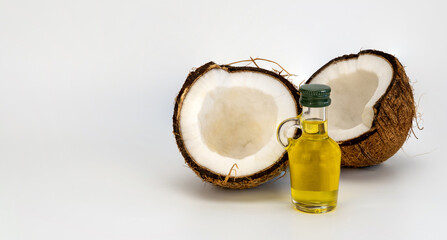 split coco and bottle on a white background. concept of cooking coconut oil.