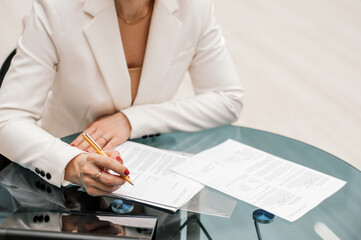 Woman signs document, emphasis on female hand and pen, supplying signature on official paper, signing name on statement with legal value, contract management, good business deal, close view