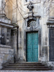 LVIV, UKRAINE - April, 2021: The Dominican church and monastery, the door with elegant and beautiful patterns on the emerald - colored doors.