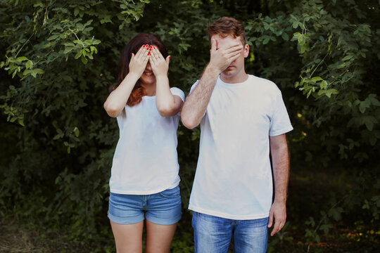 The Man And Woman Cover Their Faces With Their Palms. The Lovers Are Dressed In The Same Outfit. The Concept Of A Love Relationship, When A Couple Closes Their Eyes To All Of Each Other's Shortcomings