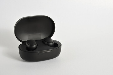 Black wireless headphones in a box on a white background.