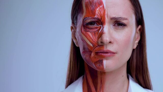 Cosmetic injection in the face. Young woman with half of face with muscles structure under skin. Model for medical training on a light background. Close up video of face human anantomy.