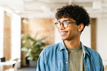 Smiling handsome african-american young man in the office - obrazy, fototapety, plakaty