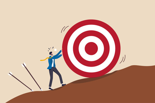 Missed target, failure or obstacle, difficulty in work that hard to achieve target or set too high or unrealistic goal concept, businessman trying hard to push dartboard or arrow target up the hill.
