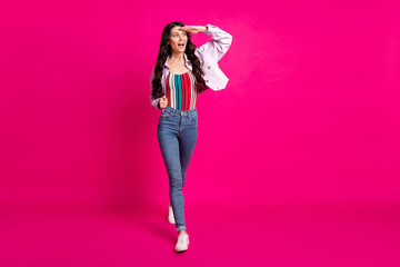 Full size photo of impressed brunette nice lady go look wear top jacket jeans sneakers isolated on pink color background