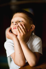 Fototapeta na wymiar emotional, cheerful portrait of a boy on a dark background, selective focus