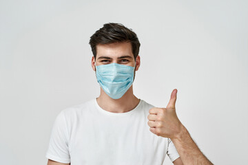 Man wearing medical mask showing the thumbs up