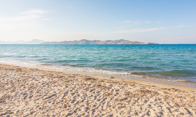 Fototapeta na wymiar Tigaki beach, Kos, Greece. Beautiful sandy beach with saturated blue water on a sunny day. Dodecanese islands, Aegean Sea