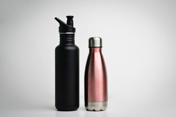 Set of modern thermos bottles in different colors on white background. Close-up of reusable, eco...