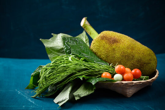 Young jackfruit and local vegetables in a basket on color background, Food ingredients for Northern Thai food (Kang Kanoon), Spicy young jackfruit soup