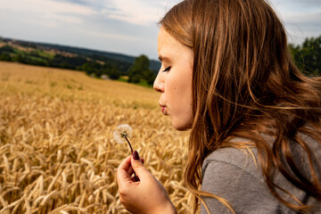 Junge schöne Frau mit Pusteblume