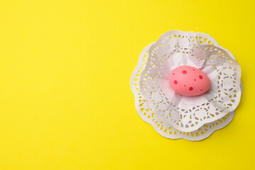 decorative pink easter egg on a yellow background, top view