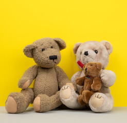 teddy bears sitting on a yellow background